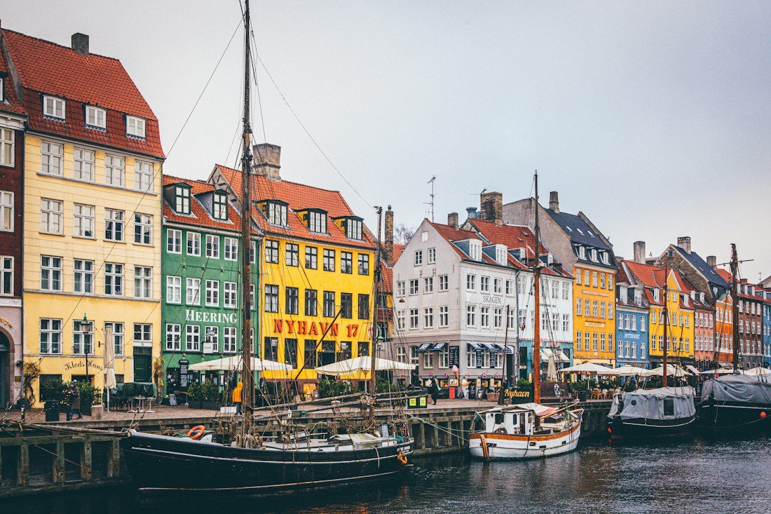 Boats moored along the colorful waterfront buildings at Nyhavn in Copenhagen